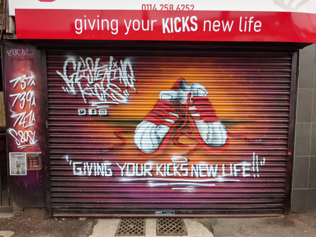 A pair of trainers painted on some shop shutters