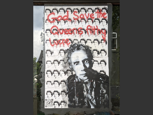 Poster featuring the Sex Pistols’ Johnny Rotten on a background of repeating Queen's heads and the words 'God, Save the Queen’s Filthy Lucre'