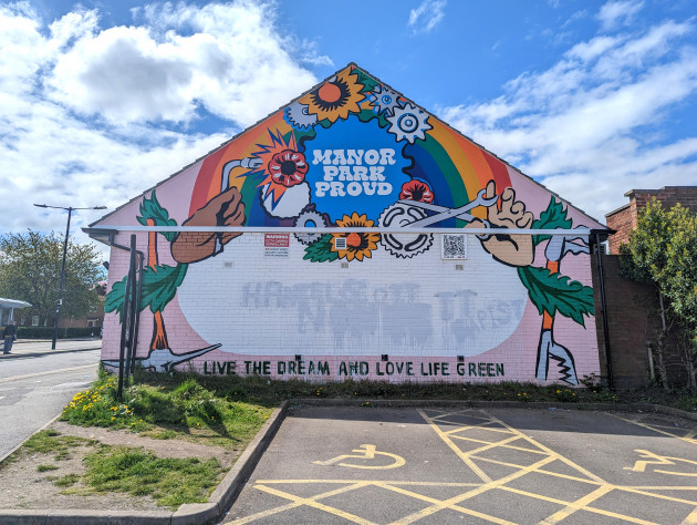 Colourful wall mural with the writing 'Manor Park Proud, live the dream and love life green'