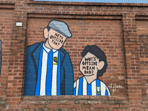 Mural of two faceless Sheffield Wednesday fans with the words 'Neva offside that' and 'wots offside mean dad?' Written over the faces