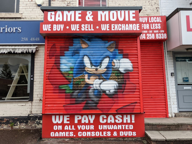 Painting of Sonic the hedgehog bursting through some shop shutters