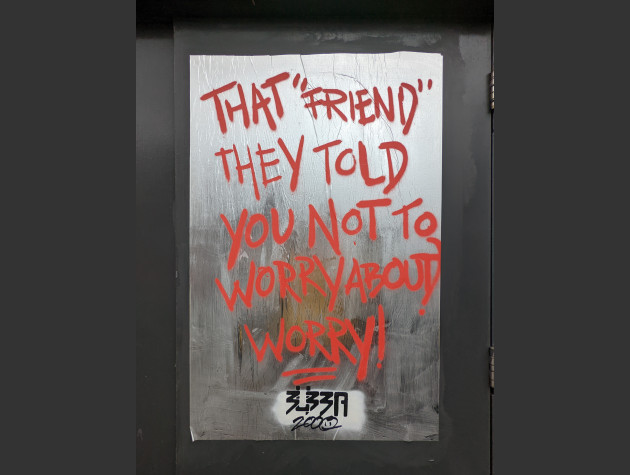 Shiny silver paste-up with the words 'That "Friend" They Told You Not to Worry About! Worry!' handwritten in red