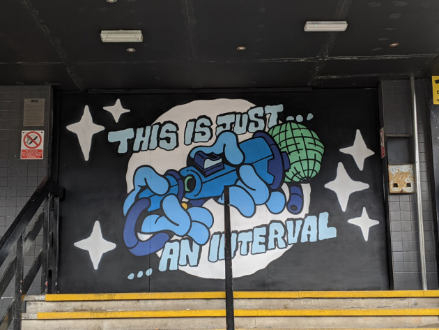 Mural showing a microphone being unplugged with the words 'This is just an interval'