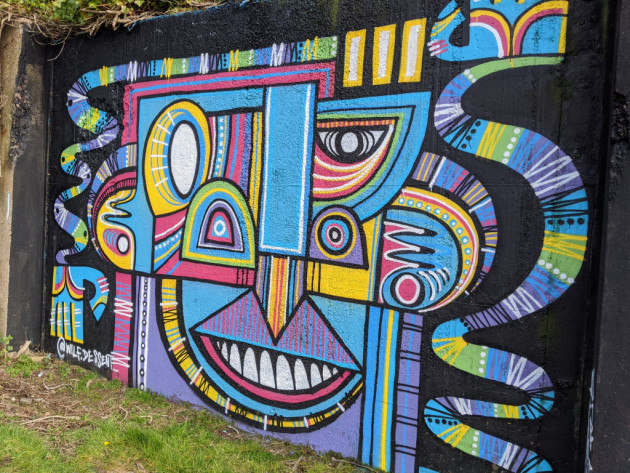 Colourful abstract mural of a face and arms