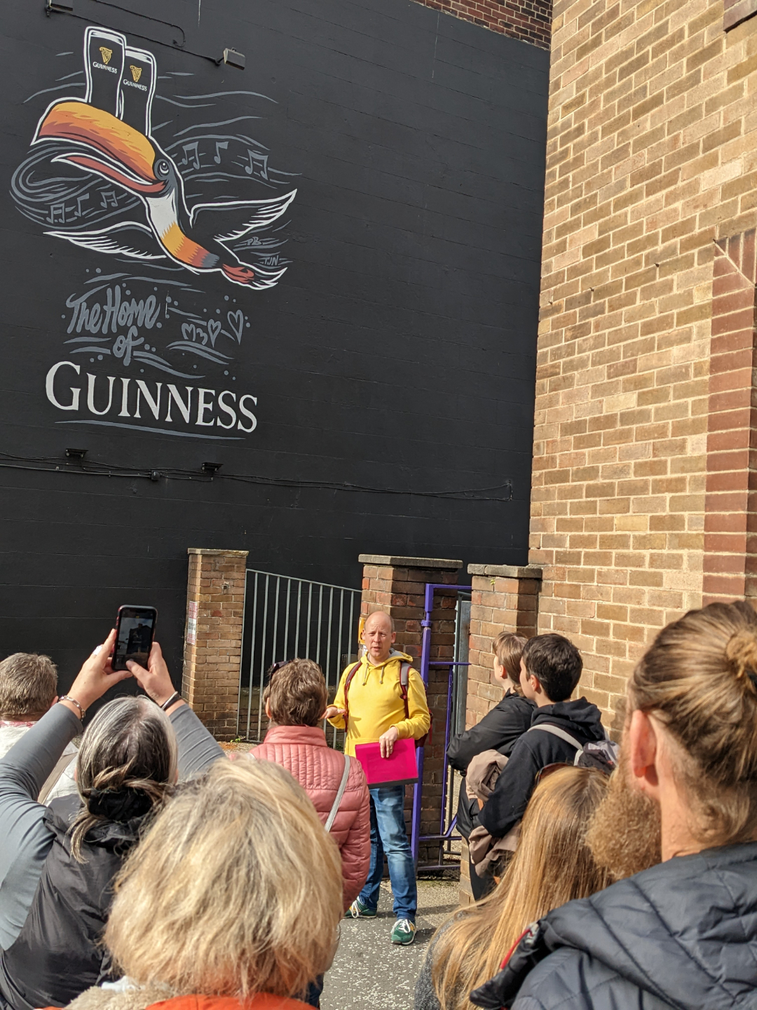 Tour group looking at a large Guinness wall mural