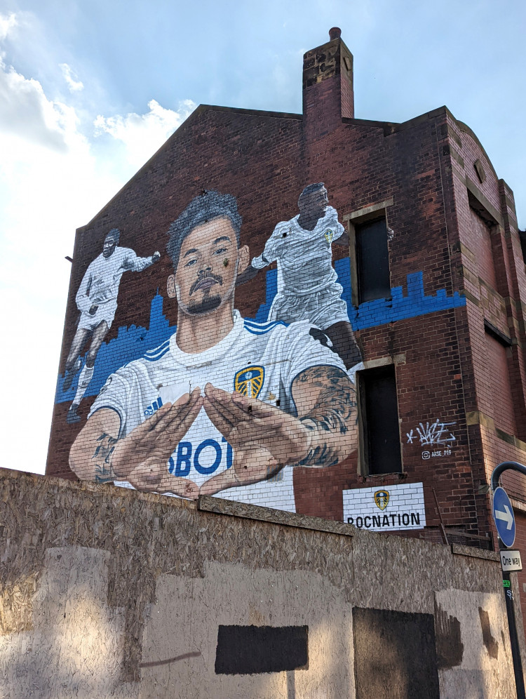 Wall mural featuring Leeds United midfielder Kalvin Phillips wearing his kit, with Albert Johanneson and Lucas Radebe in the background and the New York skyline