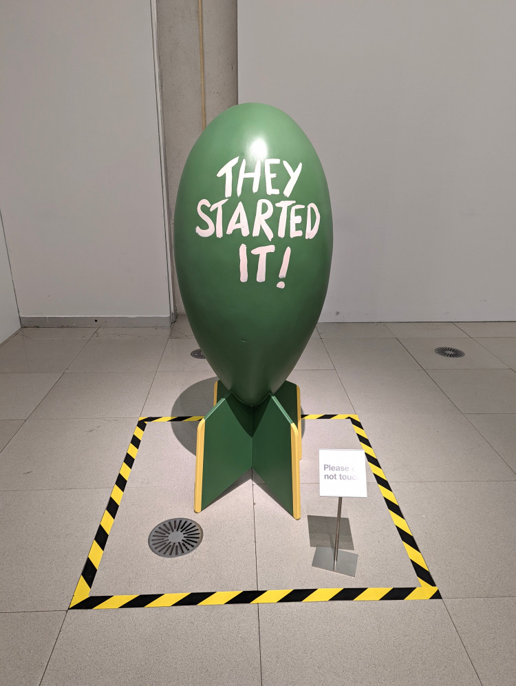 Large bomb painted green with the words 'They Started It' written in large white lettering