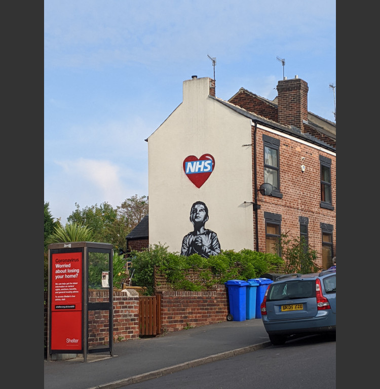 Mural of a boy looking up at a heart containing the NHS logo