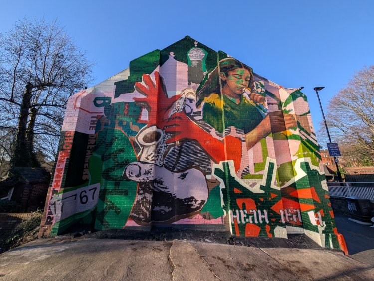 Mural featuring instruments and drinks covering a bar's facade including the glass windows