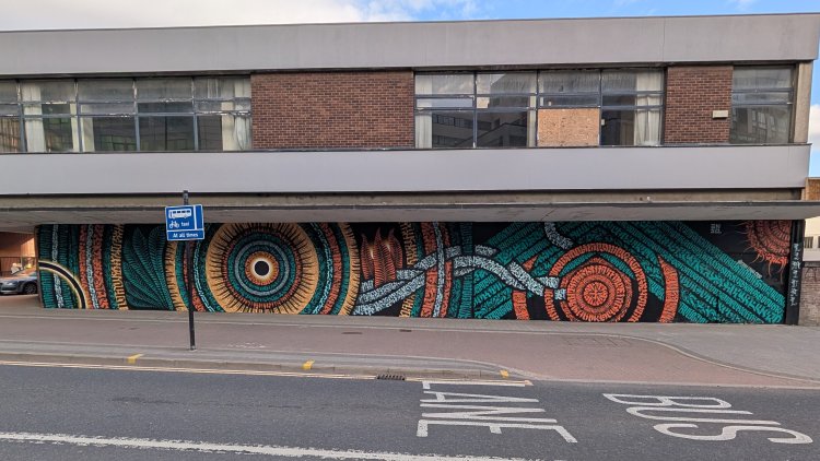Wide Enso mural formed of geometric shapes made up of calligraphy style patterns