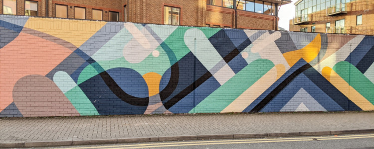 Long wall featuring a mural of coloured blobs