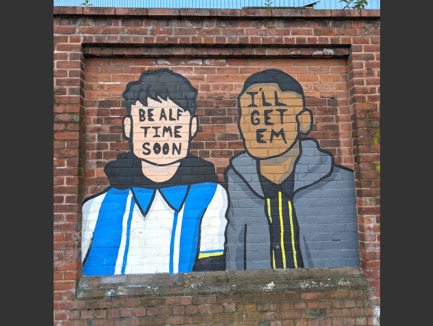 Mural of two faceless Sheffield Wednesday fans with the words 'be alf time soon' and 'I'll get em' written over the faces