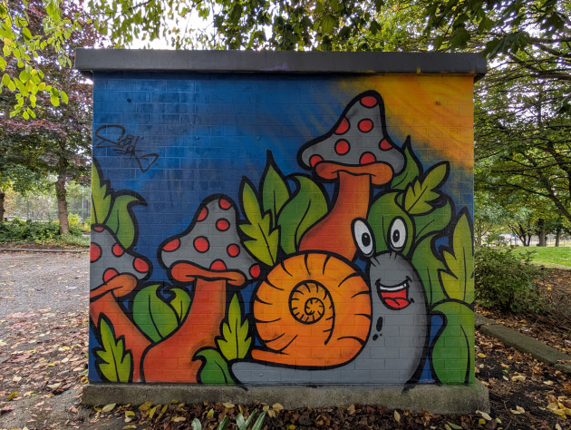 Cartoon style mural of a snail and mushrooms