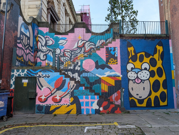 Colourful mural on walls of outdoor stairway featuring different art styles