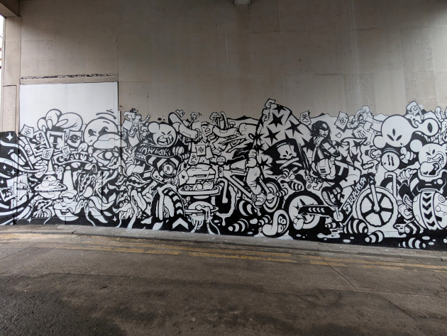 black and white wall mural featuring a detailed illustration of various characters on bikes