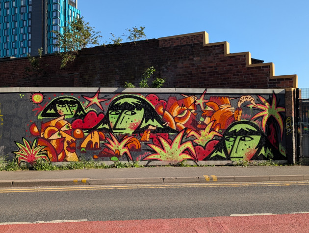 Graffiti of expressive faces rendered in two contrasting approaches: Ruok's abstract, angular designs and Ethan Lemon's more figurative, portrait-like depictions