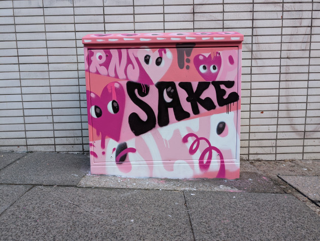 Painted utility cabinet with names of lost graffiti artists and heart shapes with emotive eyes