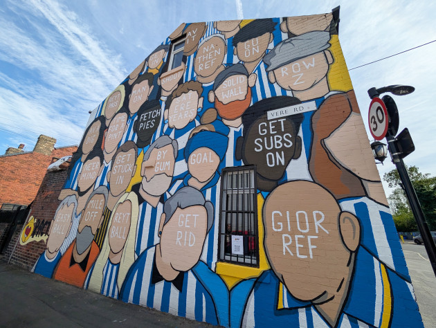 Large wall mural featuring a diverse crowd of Sheffield Wednesday fans. The crowd is faceless, with local dialect phrases replacing their facial features.