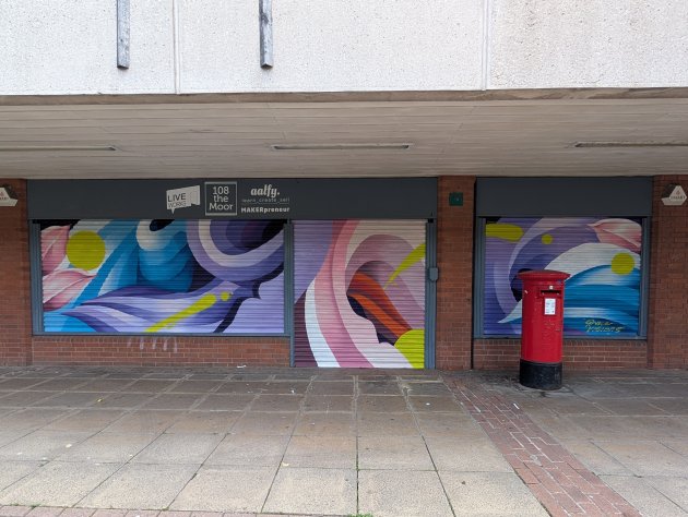 Three shutters painted with a colourful abstract floral design