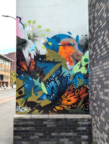 Mural featuring a robin, an orchid and a couple of monarch butterflies surrounded by an abstract design
