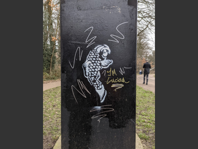 Stencil of a carp fish on the side of a utility cabinet