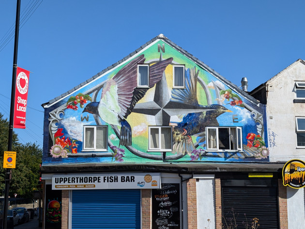 Mural featuring a directional compass, migrational birds and flowers