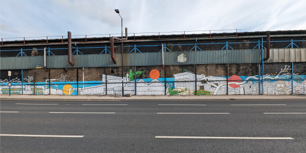 Wide mural featuring illustrations of industrial buildings and flora in different stages as the seasons progress across the wall