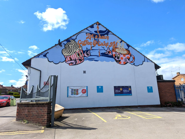 Mural featuring two cups with faces and the words 'Let's have coffee and cake kid'