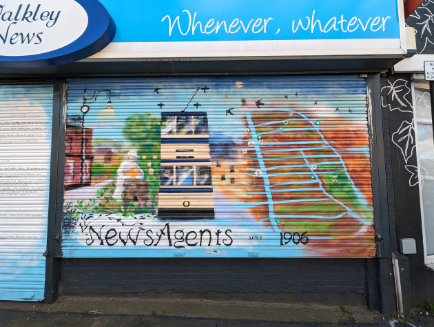 Newsagent shop shutters painted with a traditional double decker tram