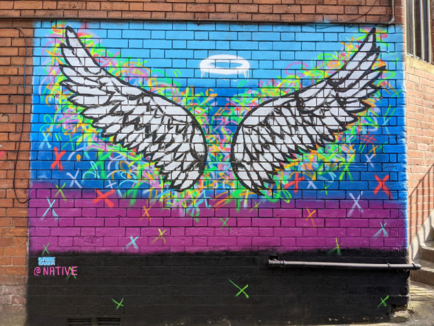 Angel wings and halo spray painted onto a wall