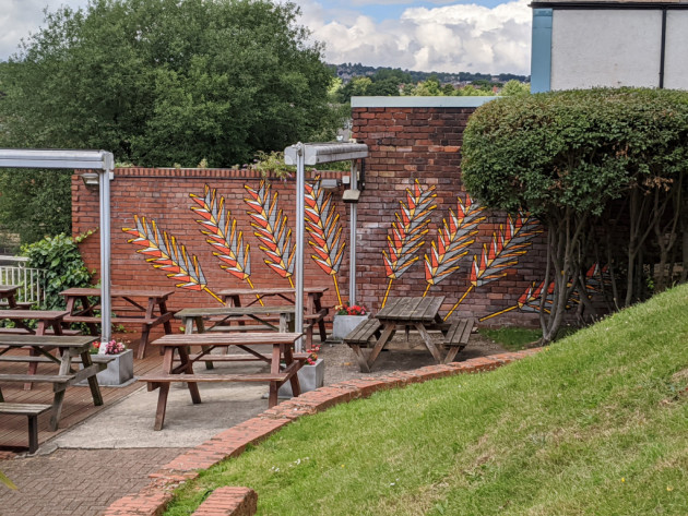 Mural of orange feathers on a beer garden wall