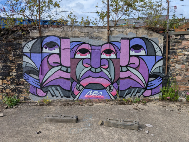 Graffiti wall featuring three guardian heads