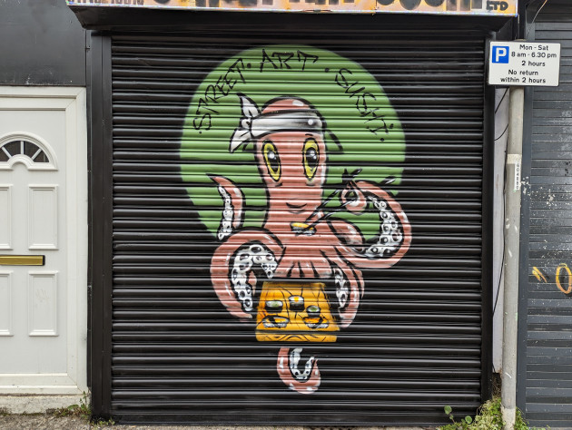 Shop shutter painted with an Octopus eating sushi from a wooden tray