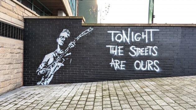 Black and white portrait of Richard Hawley playing a guitar next to the words 'Tonight the streets are ours'