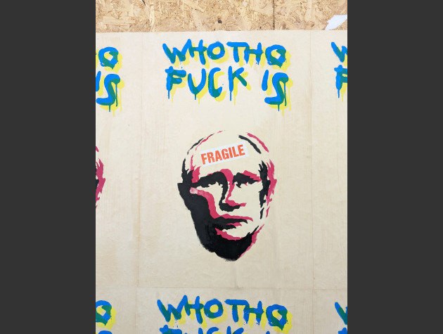 Poster showing the head of Putin with Fragile written on his forehead and the words 'who tho fuck is' above