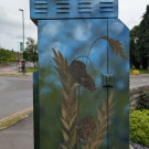 Side of the street cabinet featuring two field mice climbing stalks of wheat
