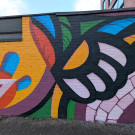 Final mural section continues the bold and vibrant abstract formation. At the centre is what appears to be part of a flower head in front of a curved stone path.