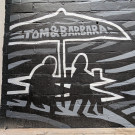 Small mural detail featuring silhouettes of Tom and Barbara enjoying a pint under a parasol